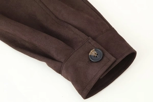 Close-up of faux suede jacket cuff with dark button and detailed stitching