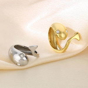 Macro detail of gold and silver whale rings with rhinestones on satin fabric