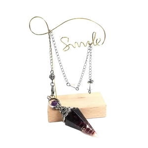Natürliches Amethyst-Kristallpendel mit Silberkette auf dekorativem Ständer