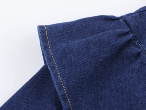 Gros plan sur le denim bleu foncé avec surpiqûres jaunes et détails de texture