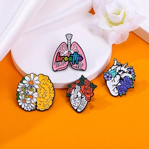 Set of 4 anatomical brain, heart, and lung enamel pins with floral motifs and text labels
