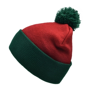 Close-up of a festive red and green knit beanie featuring a large fluffy pom-pom and ribbed cuff