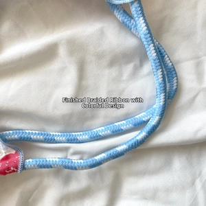 Close-up of blue and white woven tote bag strap with red floral fabric detail