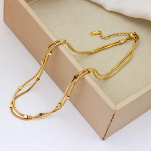 Double-layer 18K gold-plated stainless steel necklace with square beads on satin background