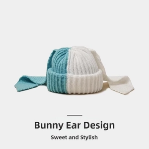 Detail of color-block knit beanie with long rabbit ears in blue and white colors