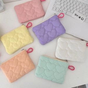Detail of six candy-colored quilted heart pouches with zippers and lanyards for storage