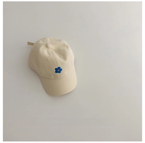 Gros plan d'une casquette en coton crème avec broderie florale bleue et texture en sergé