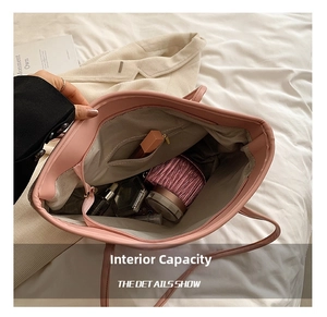 Internal view of pink tote bag showing large capacity, inner zip pocket and grey lining