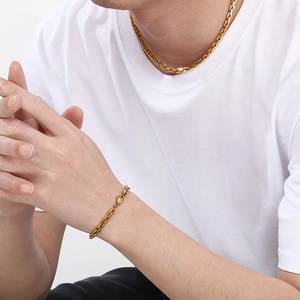 Detail eines vergoldeten Edelstahl-Gliederkettenarmbands am Handgelenk eines Mannes