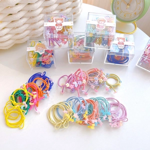 Detail showing colorful kids elastic hair ties with flower charms and a clear storage box
