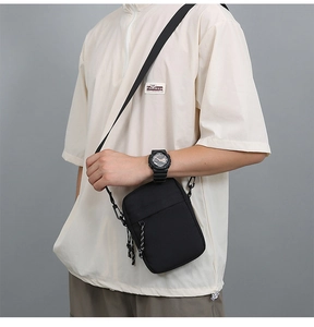 Adjustable black nylon shoulder strap with plastic hooks on a trendy small crossbody bag