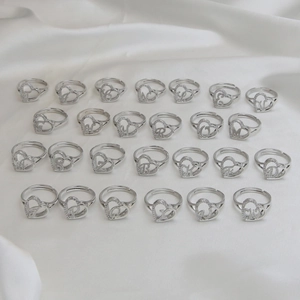 Silver adjustable heart-shaped alphabet rings with sparkling inlaid crystals on silk