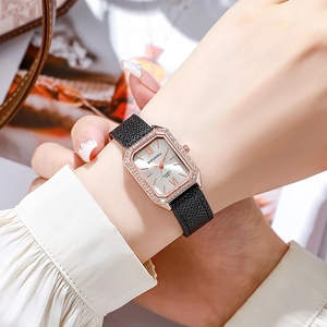Close-up of elegant rose gold rectangular watch with diamonds and black leather strap