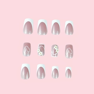 Short square press-on nails with white French tips, 3D flowers and heart patterns