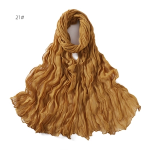 Detail of dark ginger mustard yellow pleated scarf with textured chiffon fabric finish