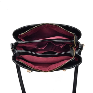 Women's black tote bag with burgundy lining showing organized triple compartment design
