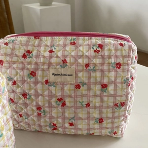 Pink and yellow quilted floral cosmetic bag with grid pattern and top zipper closure