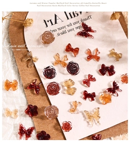 Detailed view of Maillard resin nail charms featuring bows and camellia flowers