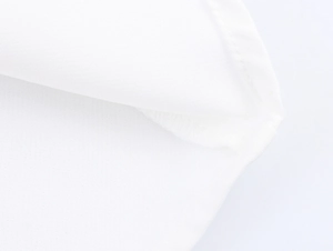Detailed close-up of the fine textile texture and stitching on the white fishtail hem