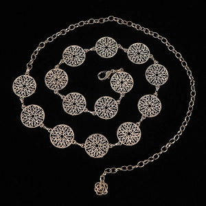 Detail of bohemian gold metal chain belt with hollow circular patterns and rose pendant