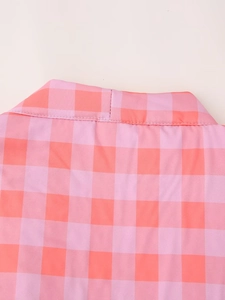 Detail shot of the pink and orange plaid fabric collar and shoulder on a sleeveless top