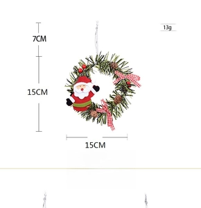 Detailed view of 15cm Christmas wreath with Santa doll, pine cones and red berries