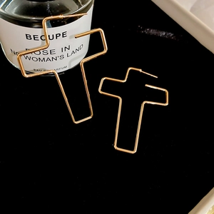 Gros plan de boucles d'oreilles croix dorées sur velours noir avec esthétique de luxe