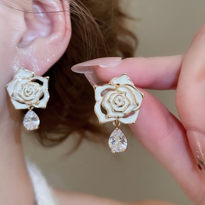 Close-up of elegant 18k gold plated flower earrings with white petals and zircon drops