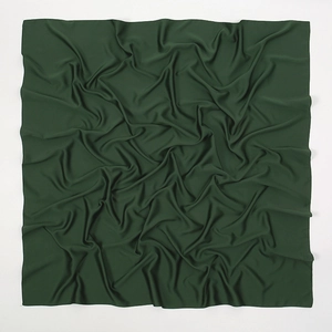 Macro shot of dark green matte satin fabric texture with soft breathable draping folds