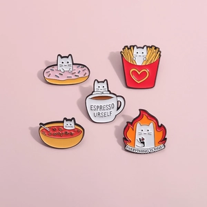 Detail of five white cat enamel pins with food motifs like espresso and fries on pink background