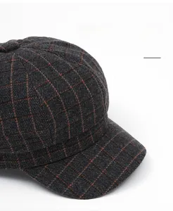 Detail of grey plaid newsboy cap with wide brim and thick wool texture fabric