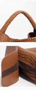 Close-up of woven leather texture and handle stitching on a brown tote bag