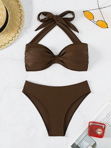 Bikini marrón con lazo al cuello en plano sobre fondo de mármol con accesorios de vacaciones
