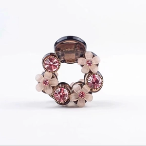 Detail of camellia hair claw with pink frosted flowers and rhinestones on resin clip