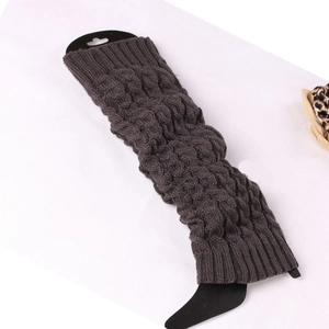 Detailed macro view of dark brown cable knit leg warmer with ribbed texture on packaging