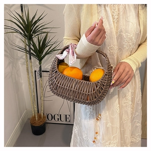 Detail of hand-woven rattan basket bag with silk scarf and decorative beaded tassels