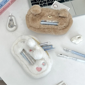 Detail of plush bear and rabbit pencil cases on desk showing soft texture and large capacity