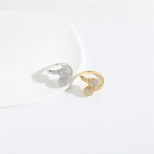 Detail of gold and silver open rings with sparkling pavé zircon spheres on a tray