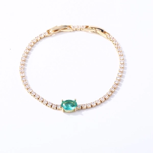 Golden tennis bracelet with green oval gem and square clear zircon in 45-degree view