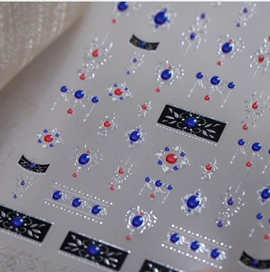 Detail of retro royal style nail stickers with ruby red, sapphire blue and silver trim
