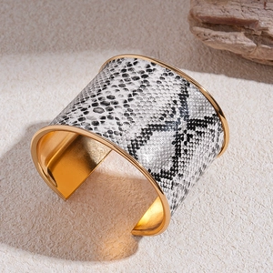 Close-up of vintage wide open cuff bracelet with grey snakeskin pattern and gold interior