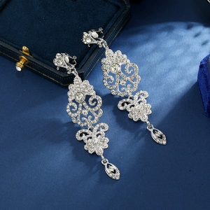 Vintage silver palace style drop earrings with crystal rhinestones on blue velvet