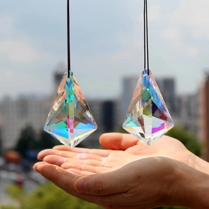 Hanging crystal suncatcher prisms creating rainbow light with sky background