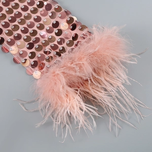 Détail de paillettes roses et bordure en plumes douces sur une robe de soirée