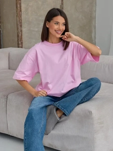 T-shirt rosa oversize in cotone con spalle scese in un contesto casual da casa