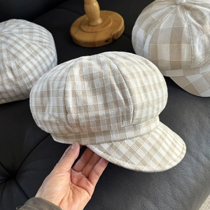 Detail showing the breathable linen texture and stitching of a beige plaid newsboy cap