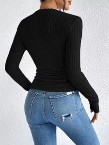 Elegant black ribbed knit top with pearls and slim fit back view paired with blue jeans