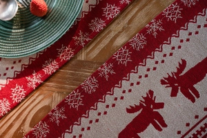 Detailed weave of red Christmas table runner featuring elk and snowflake patterns