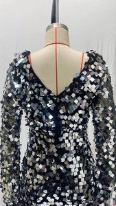 Gros plan de paillettes argentées scintillantes et col en V sur une robe de soirée