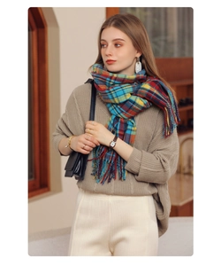 Detail of colorful plaid scarf featuring long tassels and soft cashmere-like texture